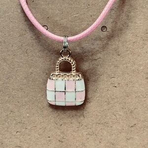 2/$15 Gold tone, purse charm with pink and white enamel checkerboard pattern.